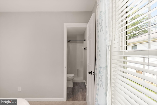 bathroom featuring wood-type flooring, toilet, and walk in shower