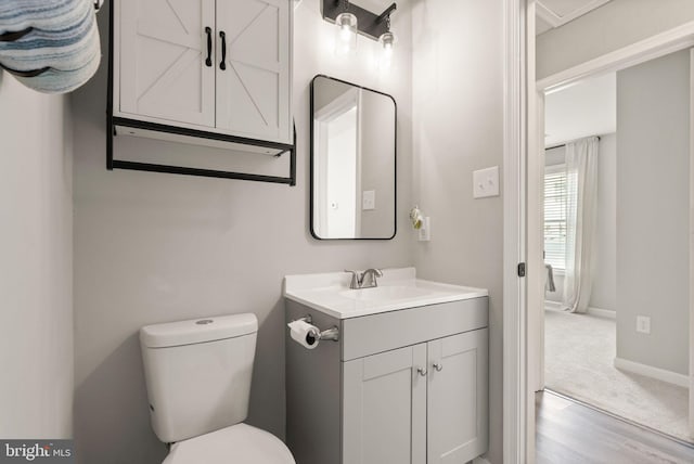 bathroom featuring toilet, hardwood / wood-style flooring, and vanity