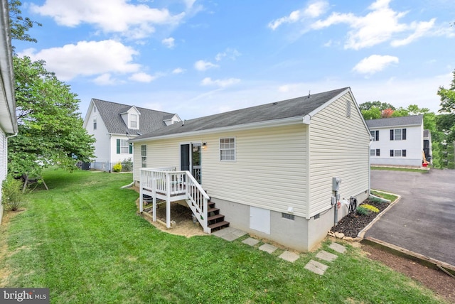 rear view of property featuring a yard