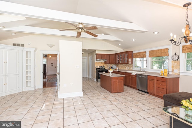 kitchen featuring ceiling fan with notable chandelier, light tile patterned floors, a kitchen island, lofted ceiling with beams, and appliances with stainless steel finishes