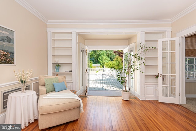 living area featuring hardwood / wood-style floors, plenty of natural light, and ornamental molding