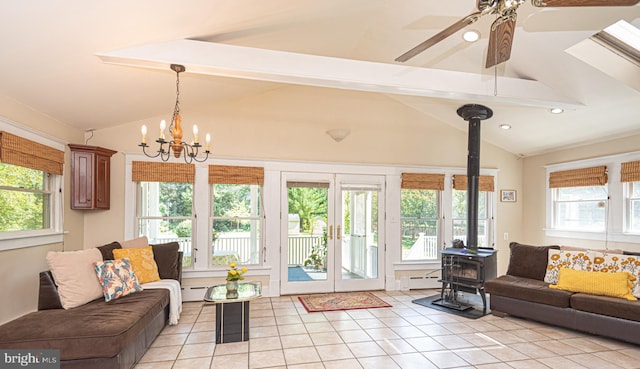 tiled living room featuring a wood stove, a baseboard radiator, ceiling fan with notable chandelier, and lofted ceiling with beams