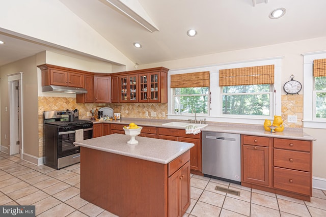 kitchen featuring lofted ceiling, plenty of natural light, appliances with stainless steel finishes, and light tile patterned flooring