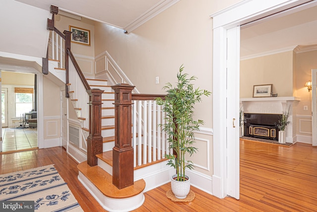 stairs with ornamental molding and wood-type flooring