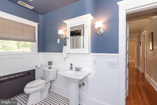 bathroom featuring toilet, hardwood / wood-style floors, and radiator heating unit