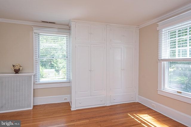 unfurnished bedroom with multiple windows, hardwood / wood-style floors, and a closet