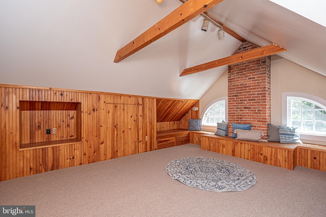 bonus room featuring a wealth of natural light, vaulted ceiling with beams, and brick wall