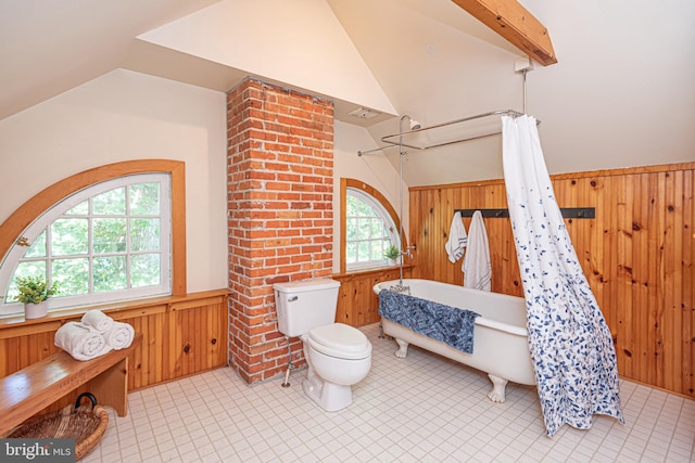 bathroom featuring brick wall, toilet, tile patterned floors, and lofted ceiling with beams