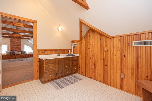 bathroom featuring tile patterned flooring, wooden walls, brick wall, vanity, and vaulted ceiling with beams