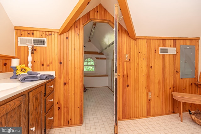 bathroom featuring wood walls, tile patterned flooring, electric panel, and vaulted ceiling