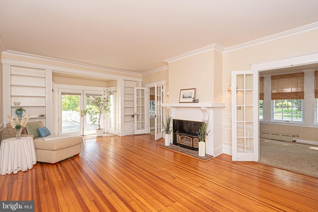 unfurnished living room featuring plenty of natural light, ornamental molding, and hardwood / wood-style floors