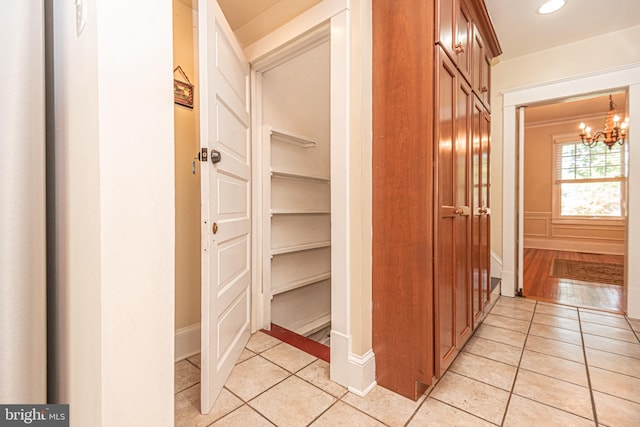 hall featuring an inviting chandelier and light hardwood / wood-style floors