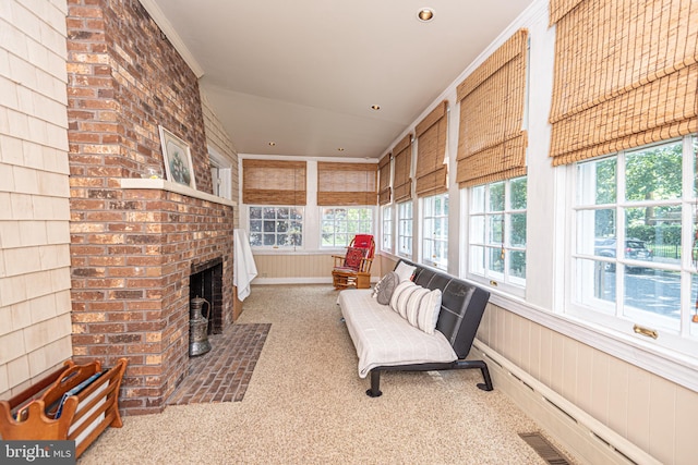 sunroom / solarium featuring a wealth of natural light, baseboard heating, and a fireplace