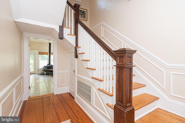 stairway featuring wood-type flooring and a wood stove