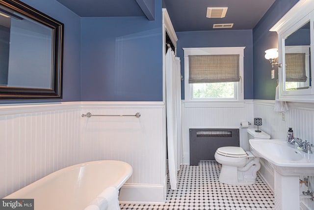 bathroom featuring a bath, tile patterned flooring, toilet, and radiator heating unit