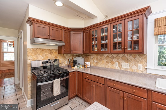 kitchen with lofted ceiling, gas stove, tasteful backsplash, and light tile patterned flooring