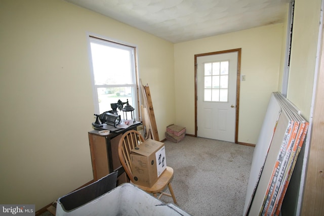 entryway featuring light carpet, plenty of natural light, and baseboards