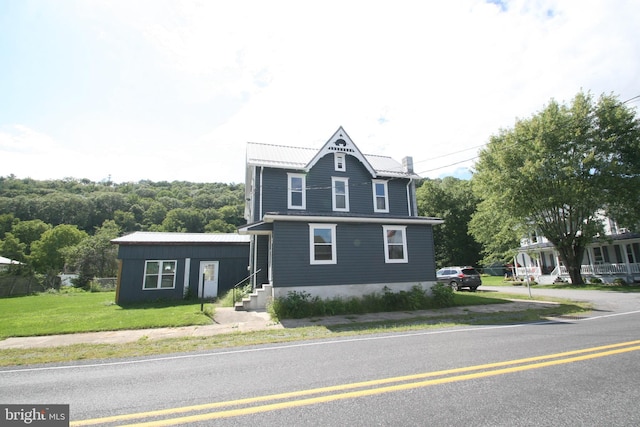 view of front facade with a front lawn and metal roof