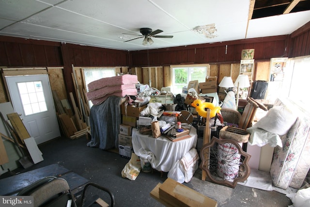 miscellaneous room with wood walls and ceiling fan