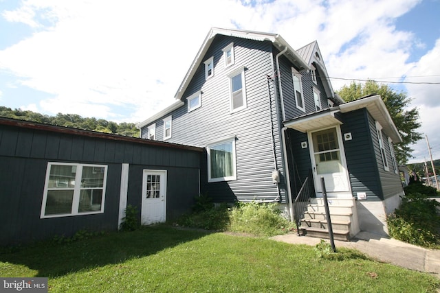 exterior space featuring entry steps and a lawn