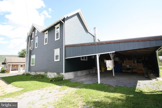 view of home's exterior featuring a yard, an attached carport, and driveway