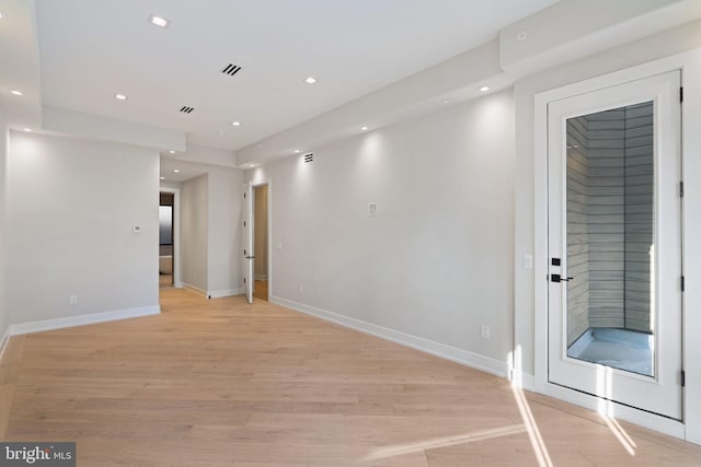 empty room featuring light wood finished floors, visible vents, and recessed lighting