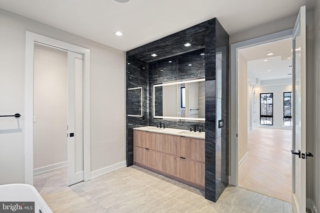 bathroom featuring recessed lighting, a sink, and double vanity