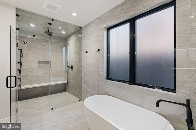 full bath featuring recessed lighting, visible vents, tile walls, a soaking tub, and a shower stall