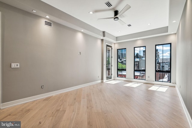 empty room with ceiling fan and light hardwood / wood-style flooring