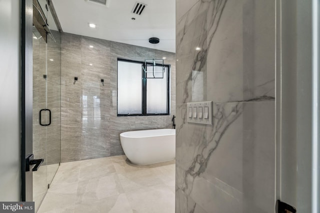 bathroom featuring shower with separate bathtub and tile walls