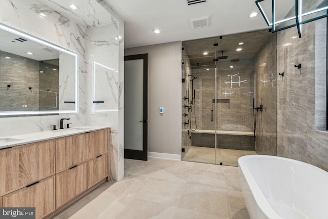 bathroom with vanity and shower with separate bathtub