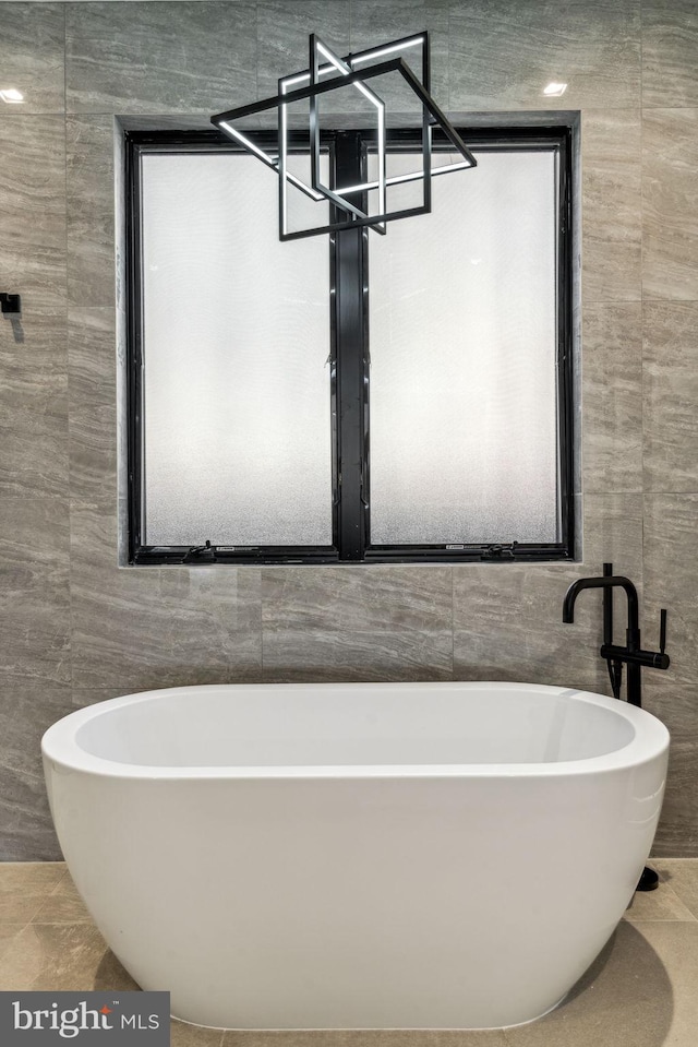 bathroom with tile walls and a tub