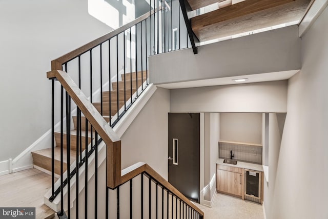 stairway featuring beverage cooler and wood-type flooring