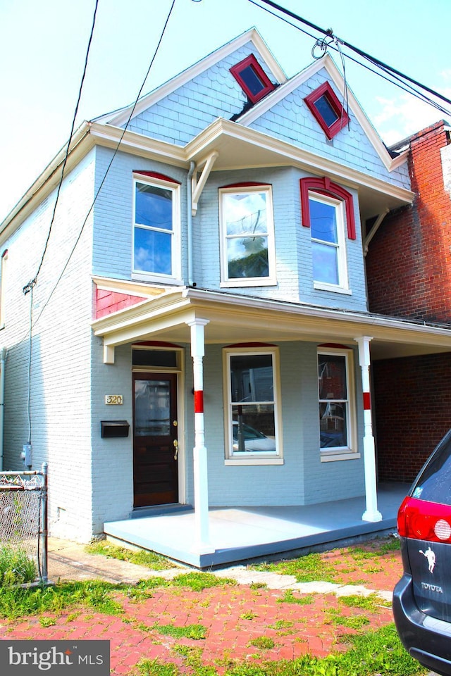 view of front of house with a porch and brick siding