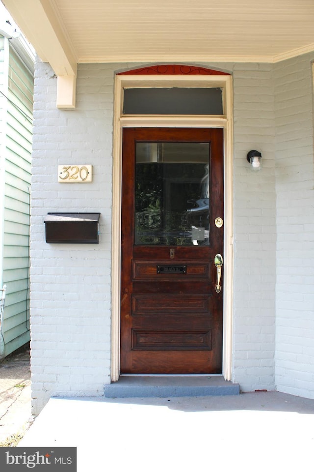 doorway to property with brick siding