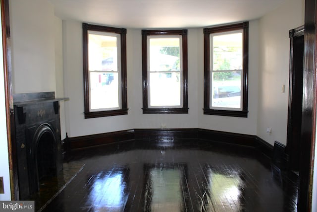 interior space featuring dark wood-style flooring, a fireplace, and baseboards