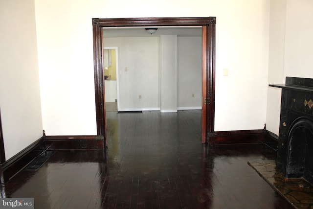 living area with dark wood-type flooring, a fireplace, visible vents, and baseboards