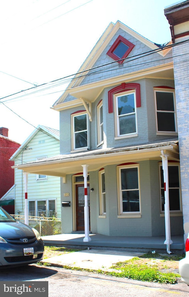 view of front of home with a porch and brick siding