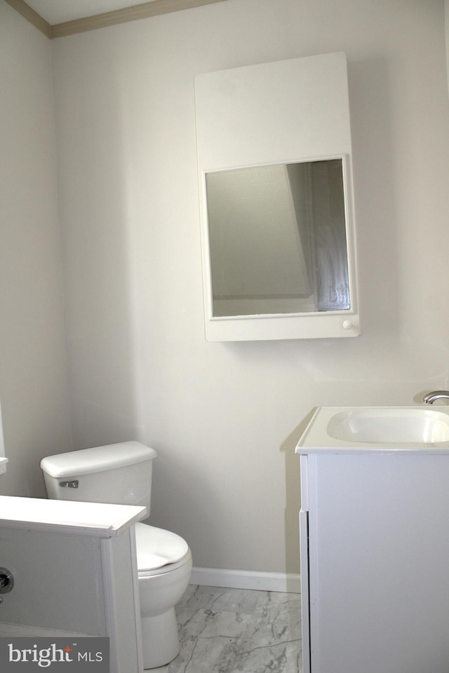 bathroom with toilet, marble finish floor, baseboards, and vanity