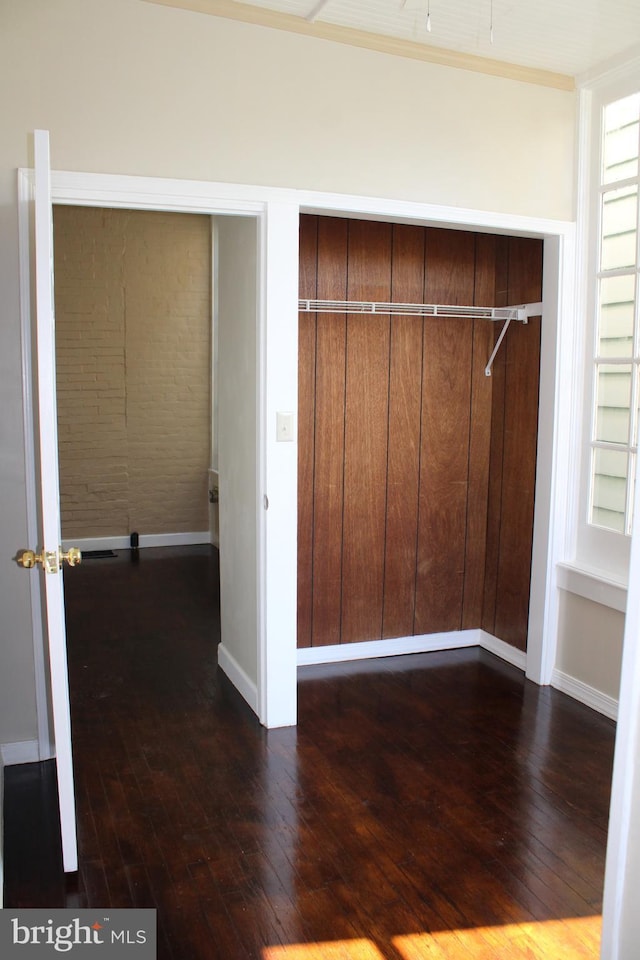 interior space featuring baseboards and dark wood-style flooring