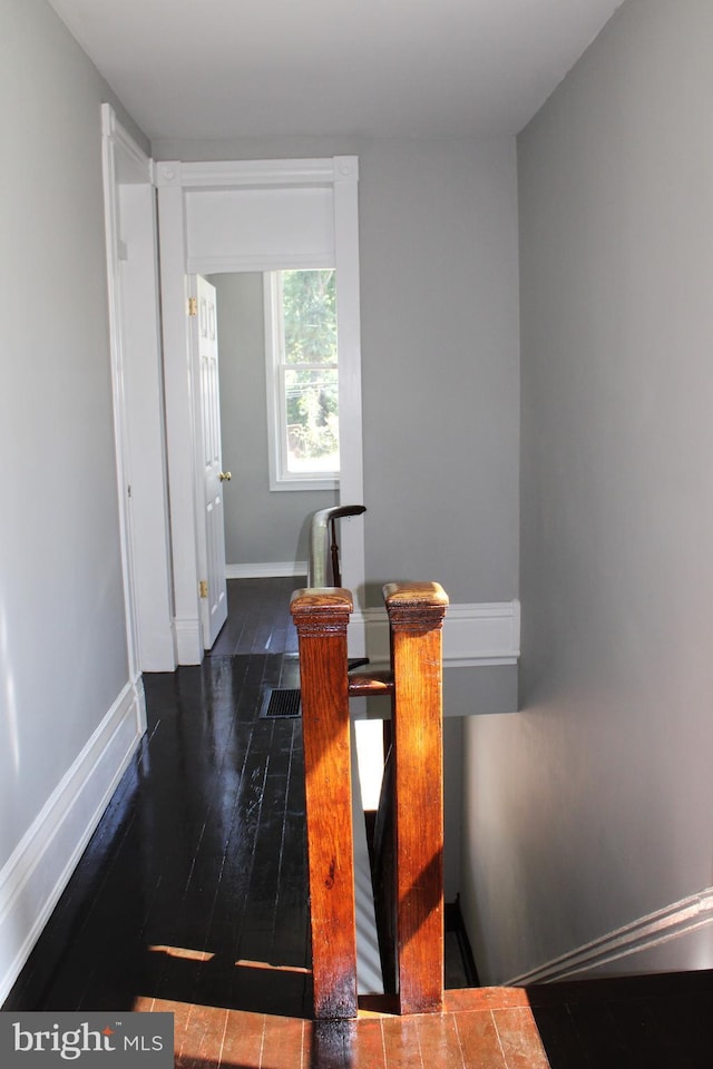 interior space featuring baseboards and dark wood-style flooring