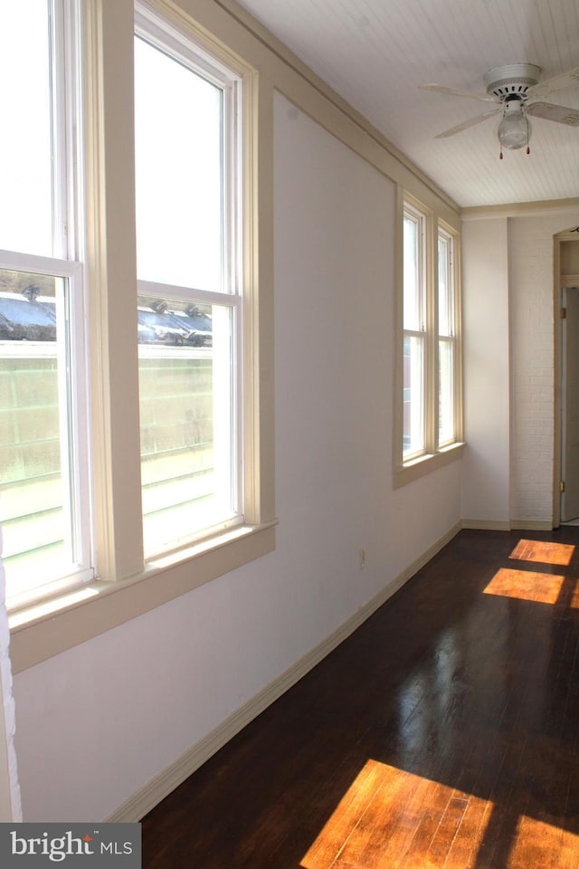 unfurnished room with ceiling fan, wood-type flooring, and a healthy amount of sunlight