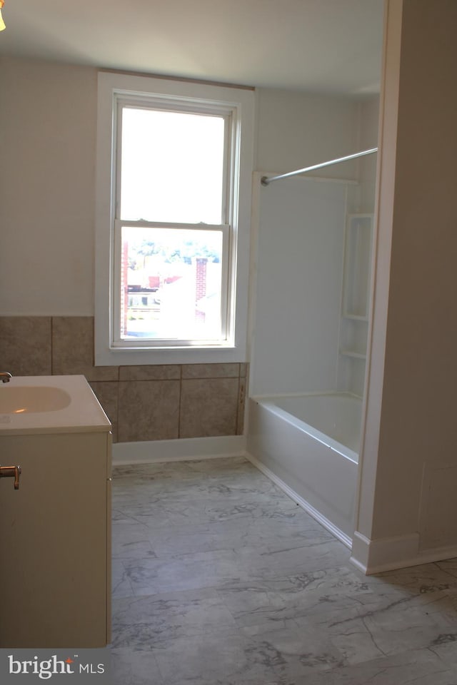 bathroom with tile patterned floors, washtub / shower combination, and vanity