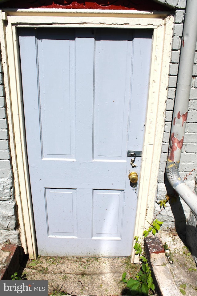 doorway to property featuring brick siding