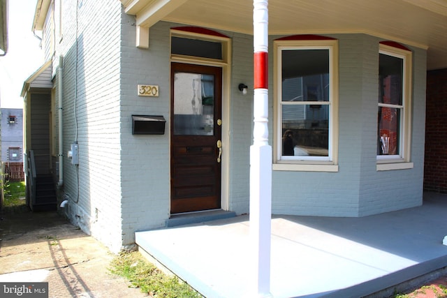 view of exterior entry with brick siding