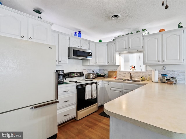 kitchen with white cabinets, sink, white appliances, a textured ceiling, and dark wood-type flooring