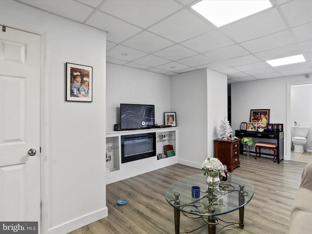 living room with hardwood / wood-style flooring and a paneled ceiling