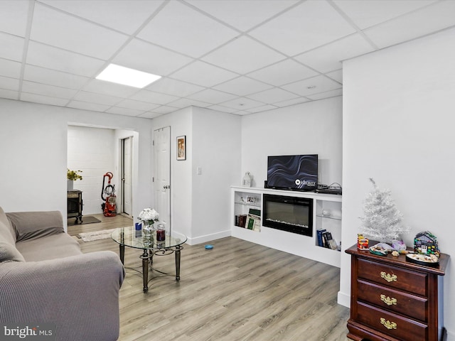 living room featuring a paneled ceiling and light hardwood / wood-style flooring