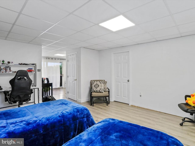 bedroom with a drop ceiling and hardwood / wood-style floors