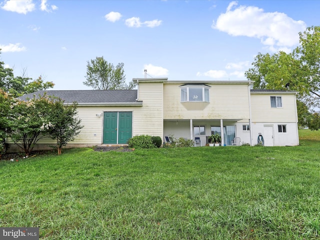 rear view of property with a lawn